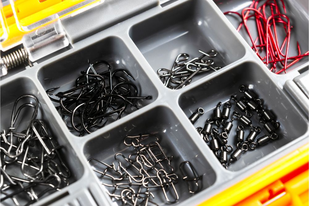 Opened tackle box with fishing hooks and accessories.