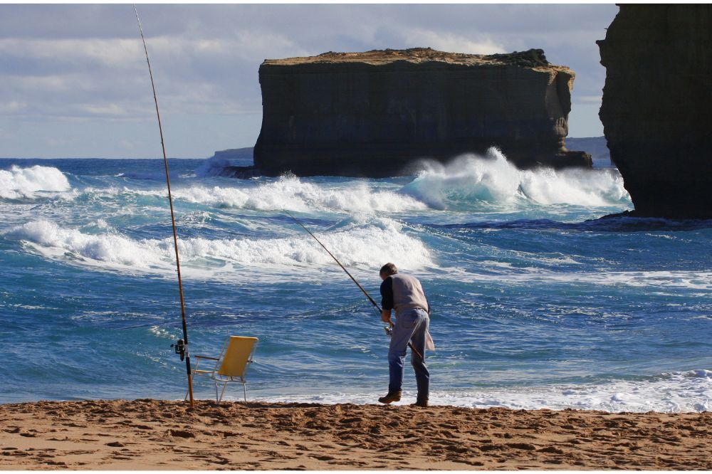 man surf fishing in strong waves