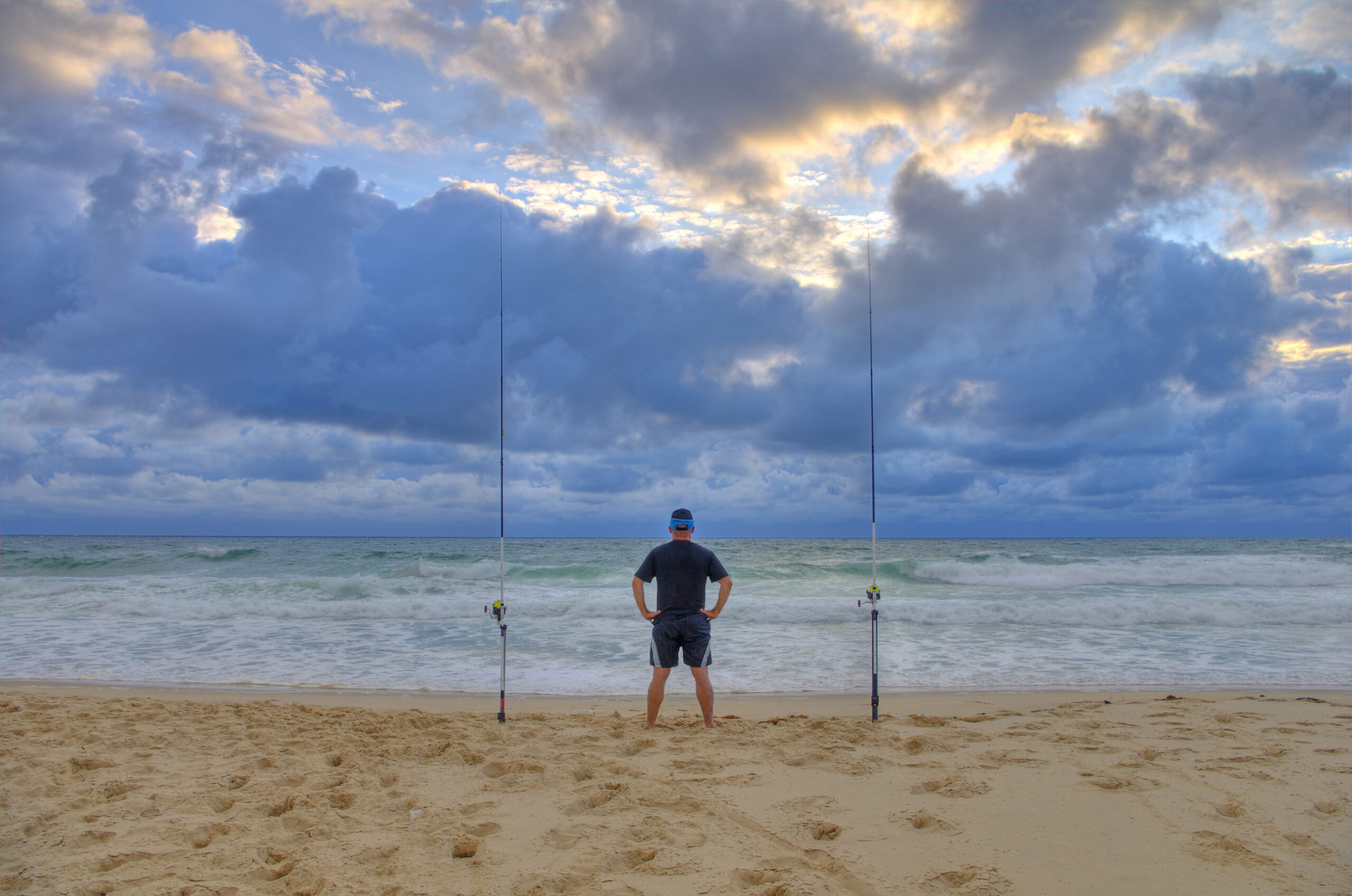 Surf fisherman waiting for fish on a beach