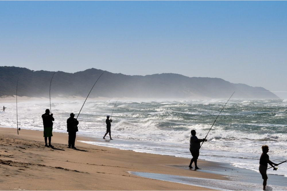 group of men fishing on sea shore