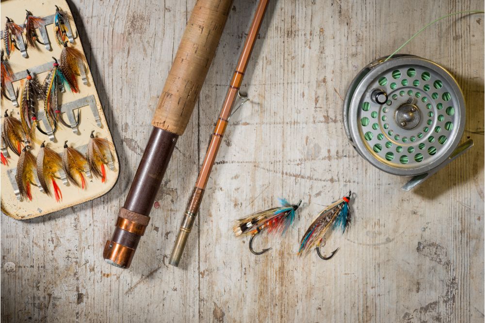 fishing lures, fishing rod, and fishing reel on table