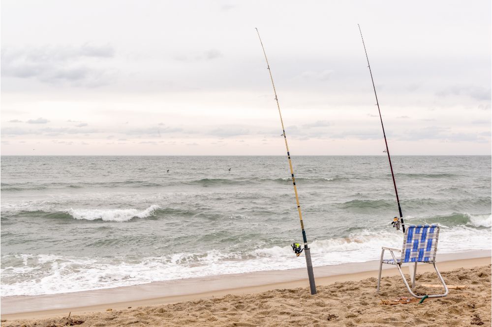 two surf fishing rod and a beach cair