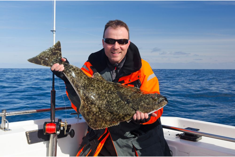 Happy angler with halibut fish