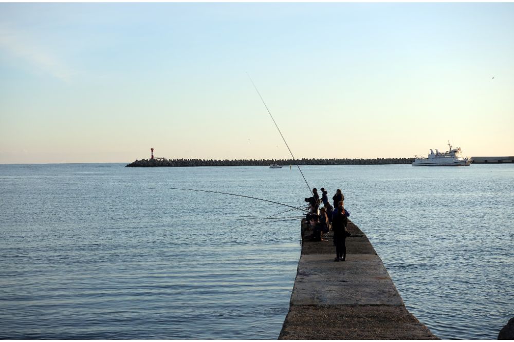 Fisherman fishes on a pier in the sea