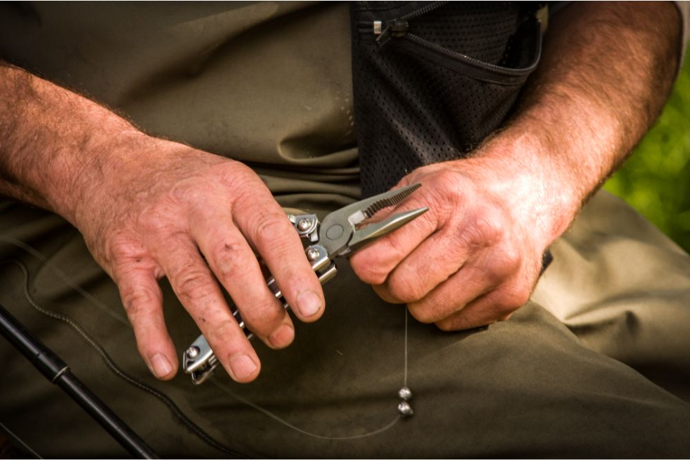 Man using multi-tool to set up fishing line