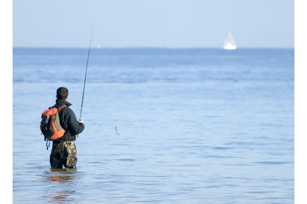 fisherman with backpack in the sea