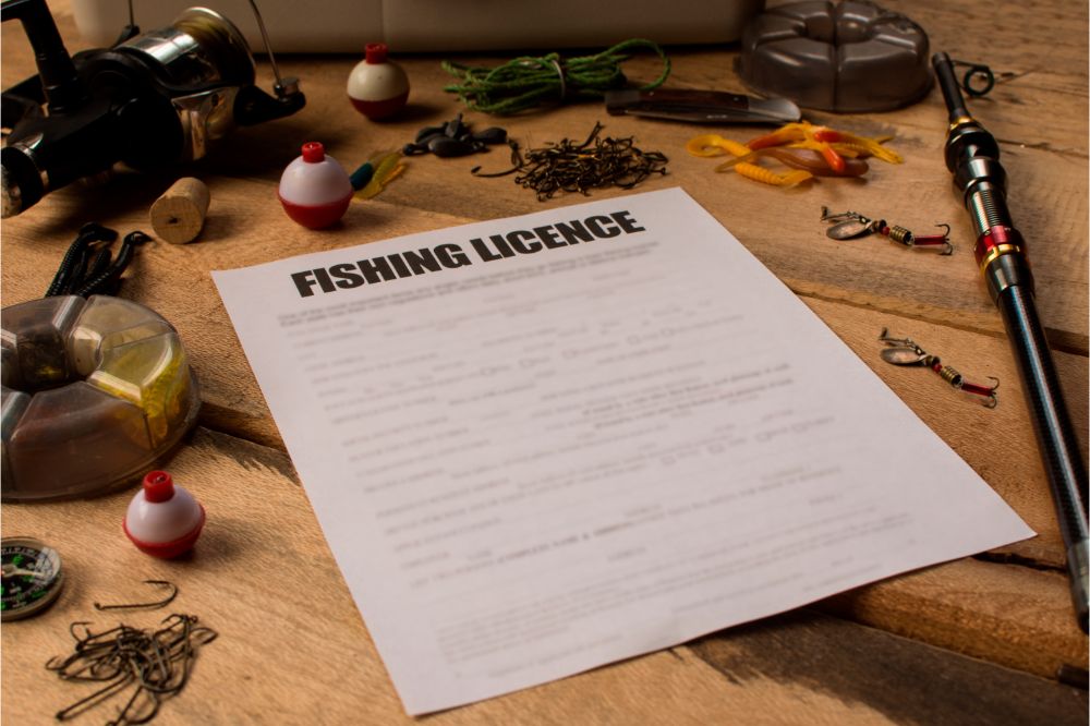 fishing license and fishing gears and accessories on wooden table