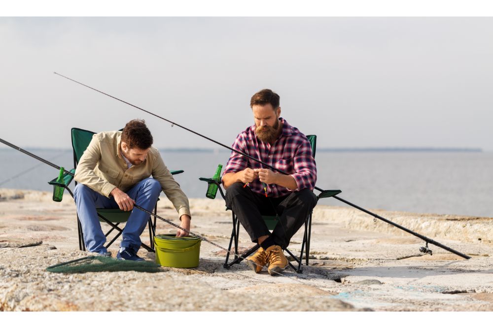 fishermen adjusting fishing rods with bait on pier
