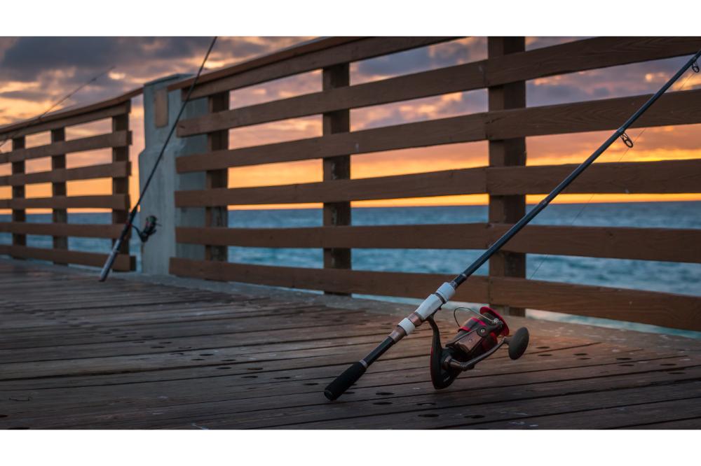Lone red fishing pole at pier at sunrise